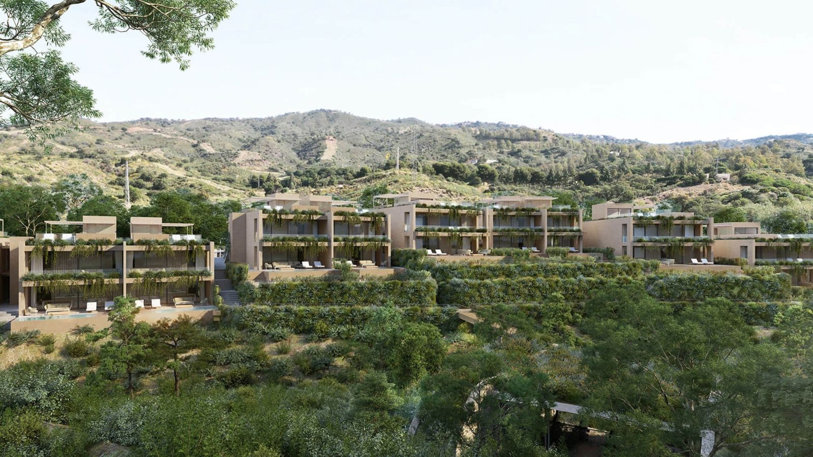 Modern multi-story hotel with balconies, scenic mountain view, lush greenery.