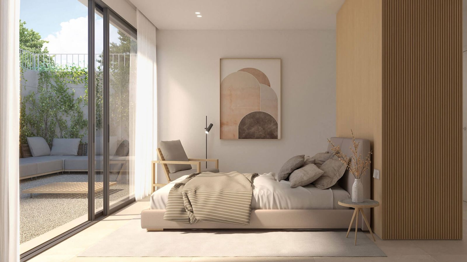 Modern bedroom with large windows, offering a view of a patio and garden.
